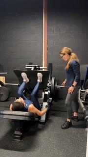 Debra Basch correcting a client's technique on the training floor at Hammer Fitness